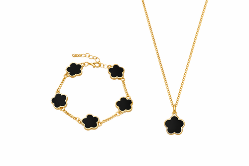 Gold bracelet and necklace with black flower-shaped charms on a white background