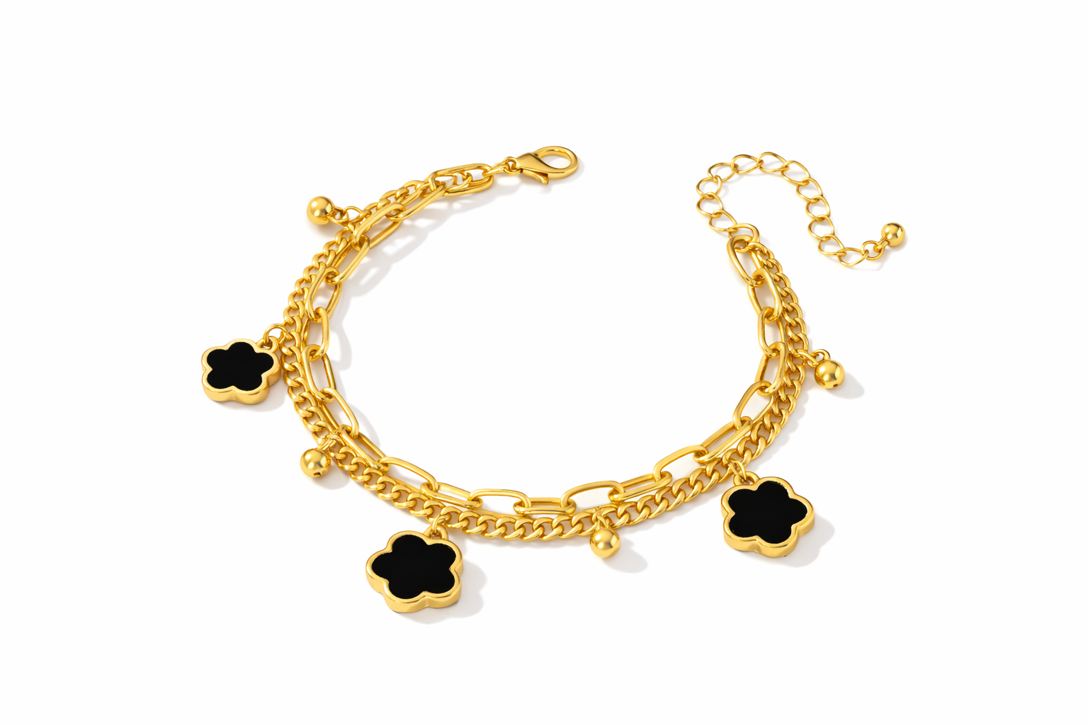 Gold bracelet with black clover charms on a white background