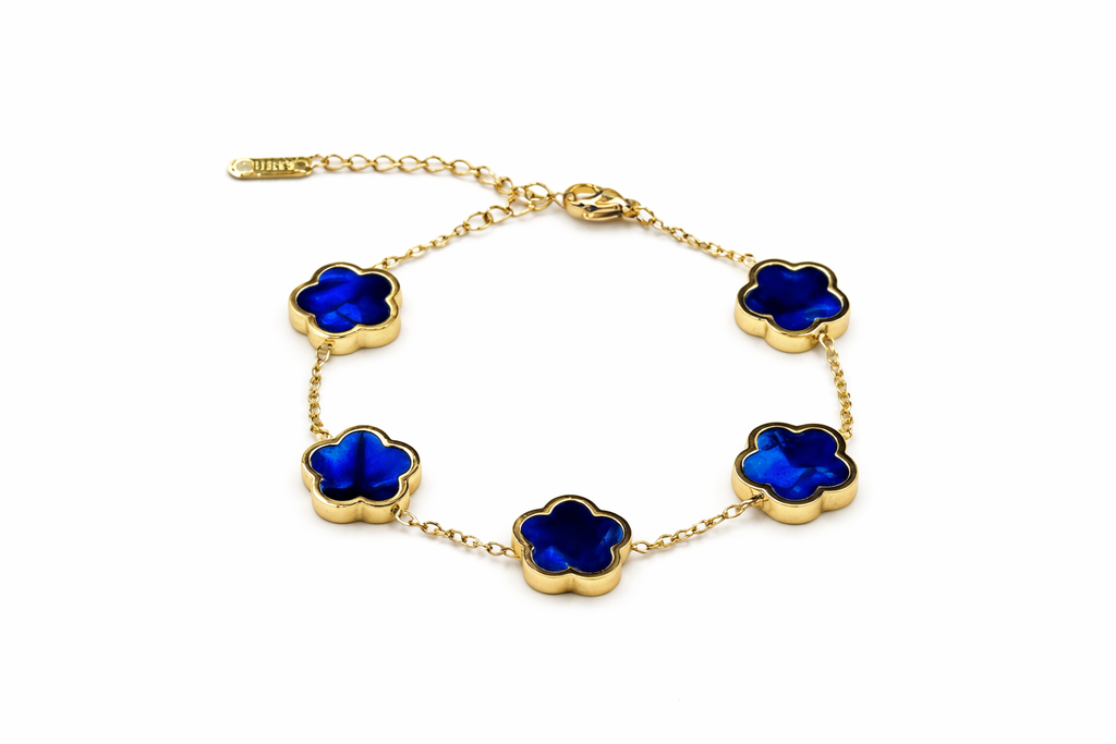 Gold bracelet with blue flower-shaped charms on a white background