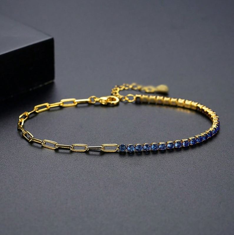 Gold bracelet with blue stones on a dark gray background