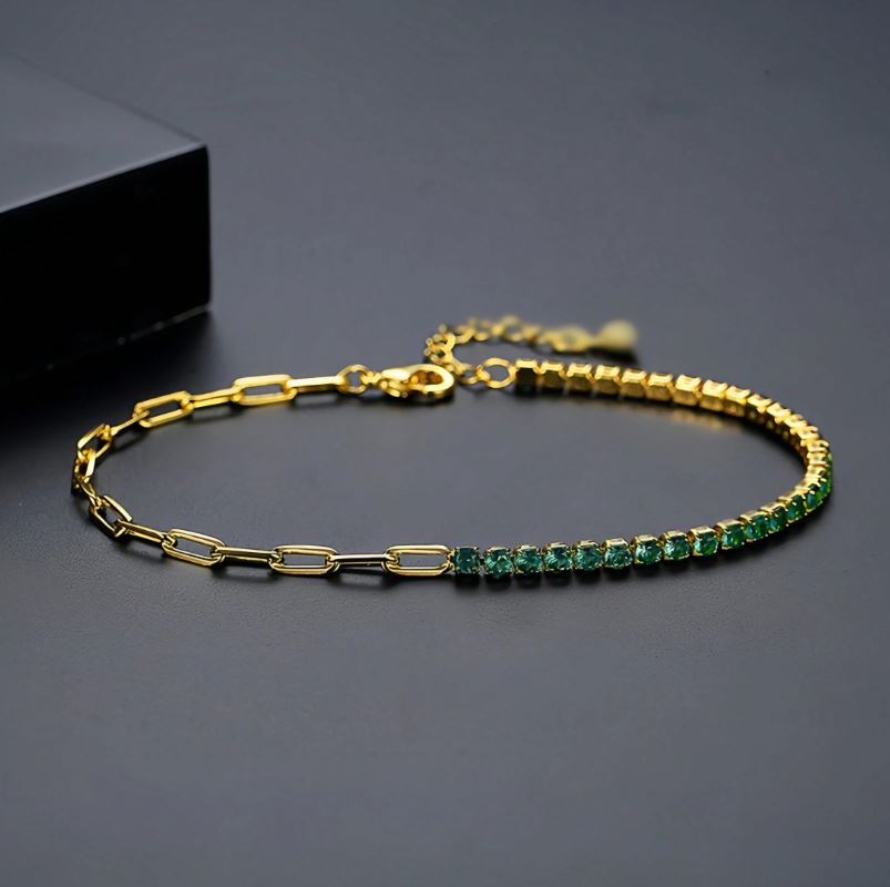 Gold bracelet with green gemstones on a dark background