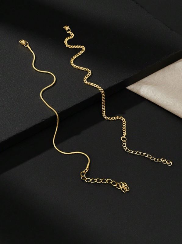Gold chain necklace on a black surface