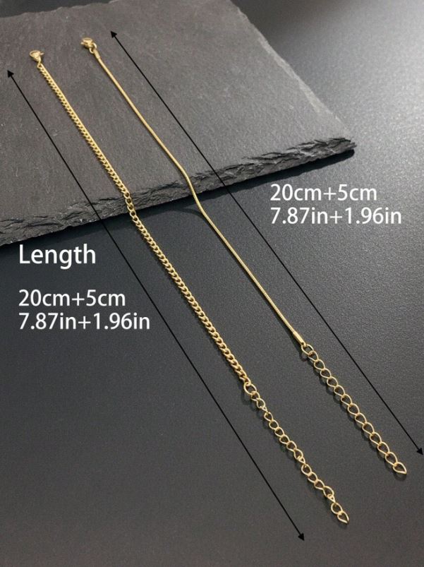 Gold chain necklace on a dark surface with measurements indicated.