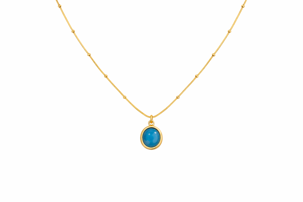 Gold necklace with a blue pendant on a white background