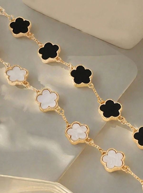 Gold necklace with clover-shaped links on a light background