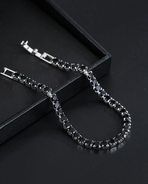 Silver bracelet with black stones on a dark surface