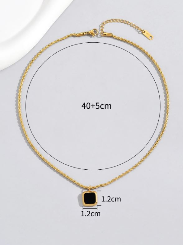 Gold necklace with a black square pendant on a white background